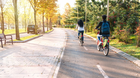 Two people biking on a road