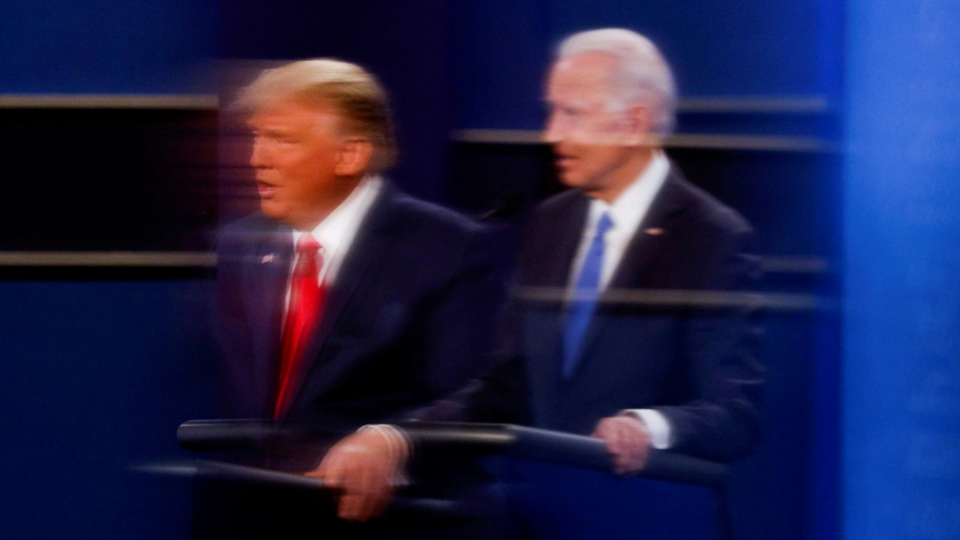 U.S. President Donald Trump and Democratic presidential nominee Joe Biden are reflected in the plexiglass during a presidential debate