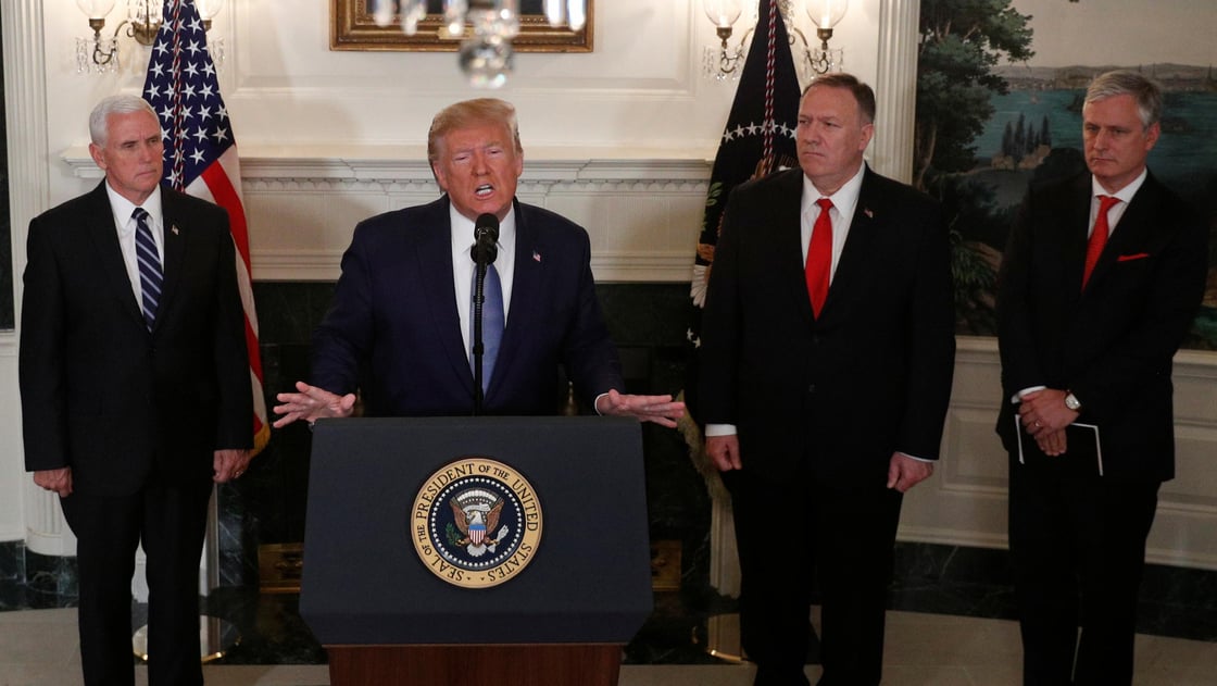 U.S. President Donald Trump delivers a statement on the conflict in Syria as advisers look on