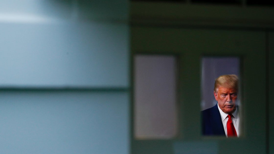 U.S. President Donald Trump participates in the daily coronavirus response briefing as seen through a window from outside of the White House press briefing room