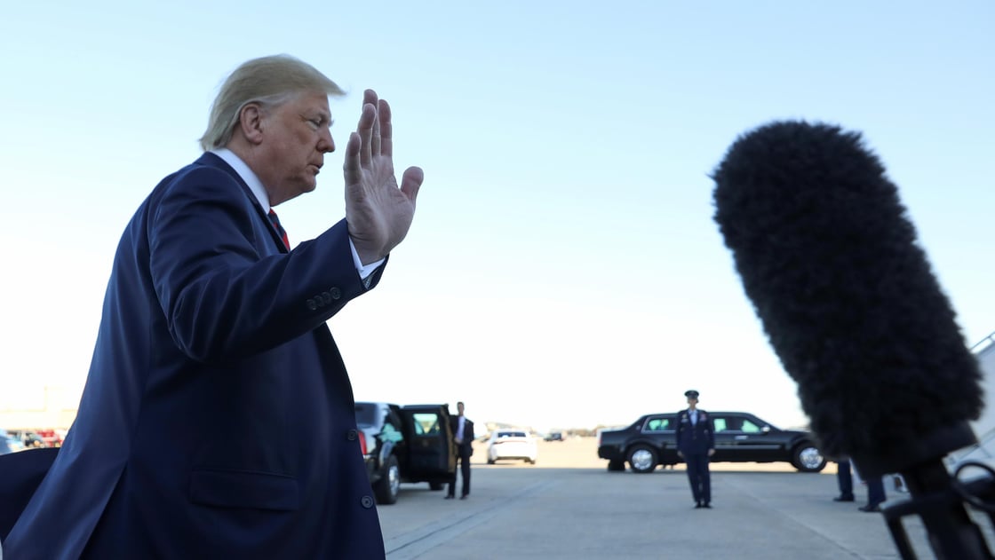 U.S. President Donald Trump waves to reporters prior to departing Washington for travel to Chicago