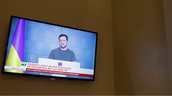 Ukrainian President Volodymyr Zelenskiy is seen on a TV screen in a hotel during a live news broadcast of the Russia Today channel