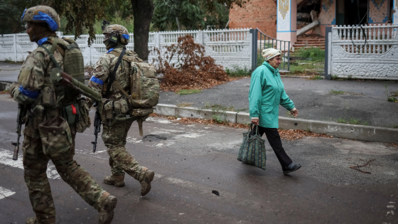 Ukrainian servicemen patrol an area in the town of Izium