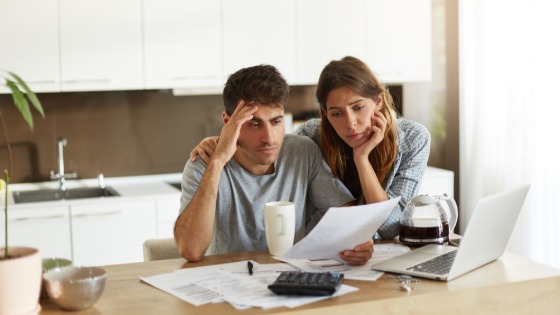 Unhappy American couple managing home accounts in kitchen