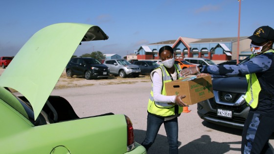 Volunteers put box in a car