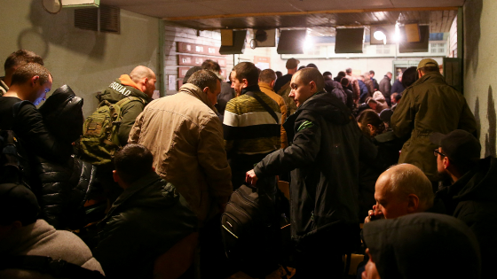 Volunteers wait in line to join the Ukrainian Armed Forces at a military commissariat in Kyiv