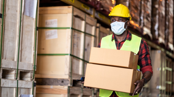 Warehouse worker carries boxes