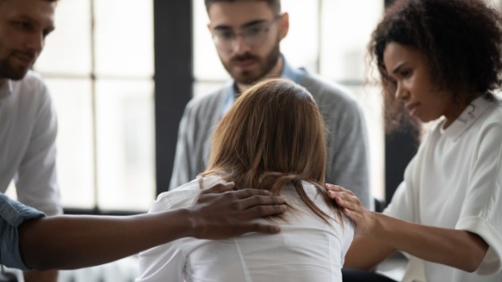 Woman being comforted by a support group