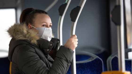 Woman on bus with mask.