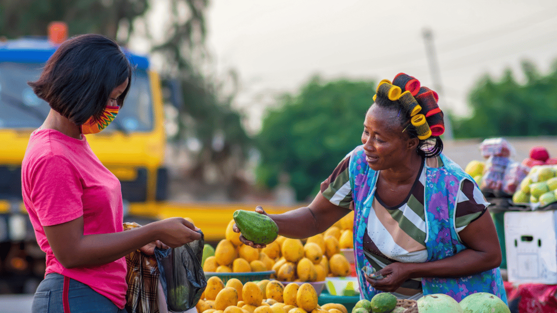 Woman purchasing fresh produce from vendor