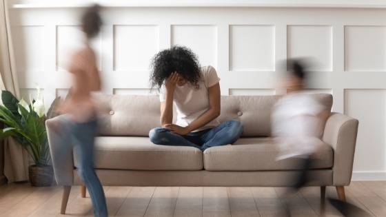 Woman sitting on couch with children around