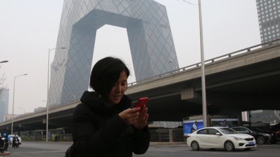 Woman uses her smartphone in Beijing