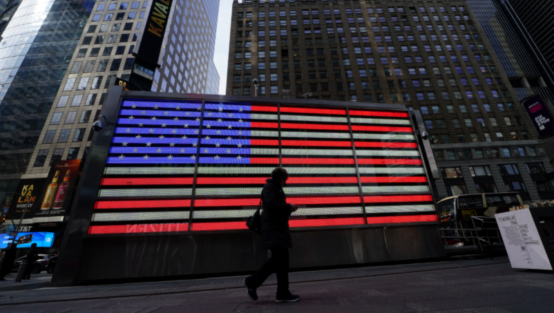 Woman walking by U.S. flag display in New York