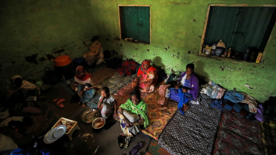 Women sit in their shelter at a camp for the internally displaced