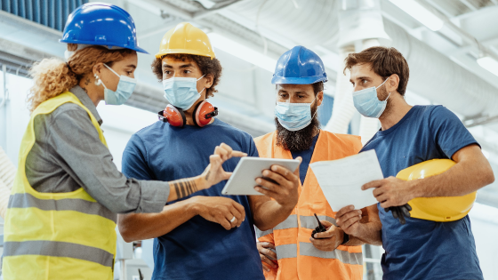 Workers in masks speaking with each other