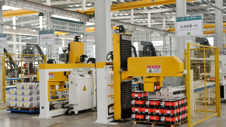 Workers operating equipment in a workshop at a hardware manufacturing company in Handan, China