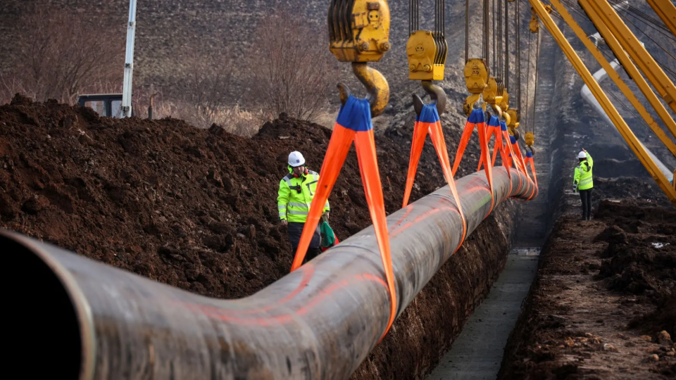Workers stand next to a pipe at the launch of the construction of an interconnector gas pipeline to link the gas networks of Bulgaria and Serbia