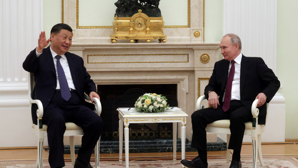 Xi and Putin sit together at a meeting.