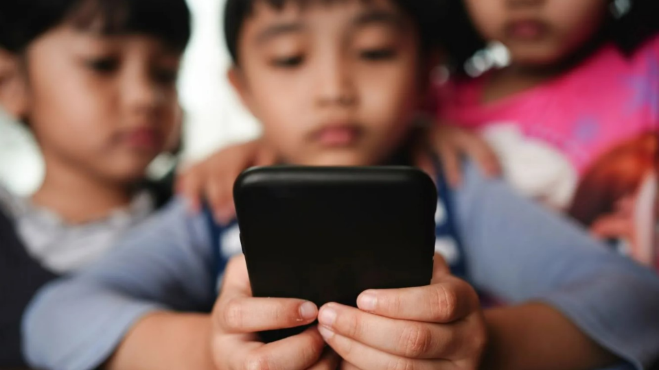 Young children looking at phone