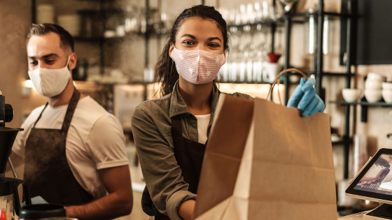 Young people working in coffee shop with masks on