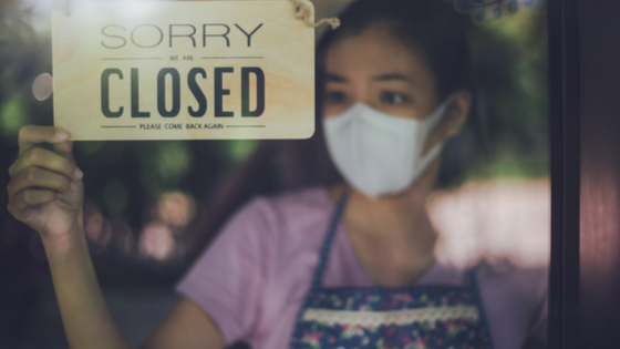Young worker putting up closed sign